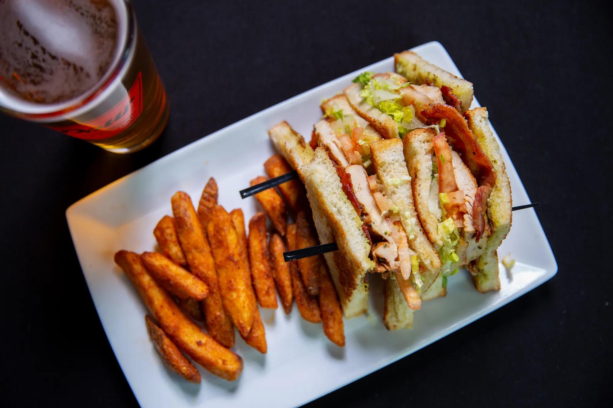 Club sandwich with sweet potato fries at Pour Taproom Jacksonville