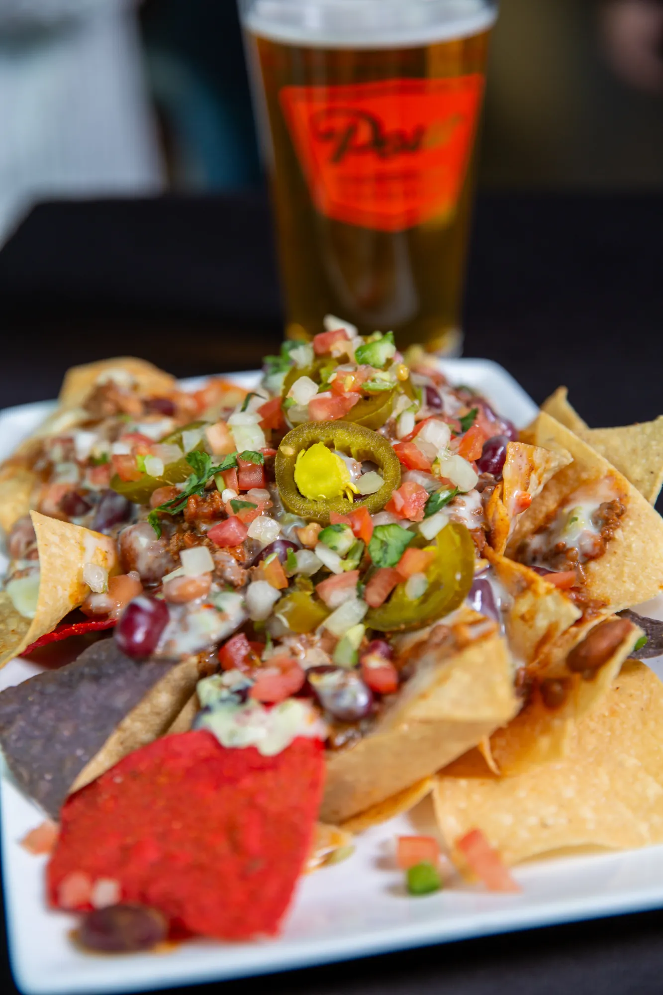 Loaded nachos and a draft beer at Pour Taproom Jacksonville